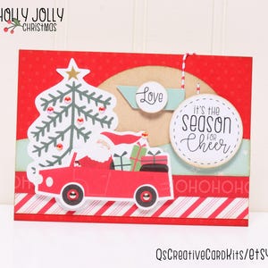 May include: A red Christmas card with a white Santa Claus driving a red car with a Christmas tree in the back. The card has a red and white striped border and the text "It's the season for cheer" and "Love" on it.