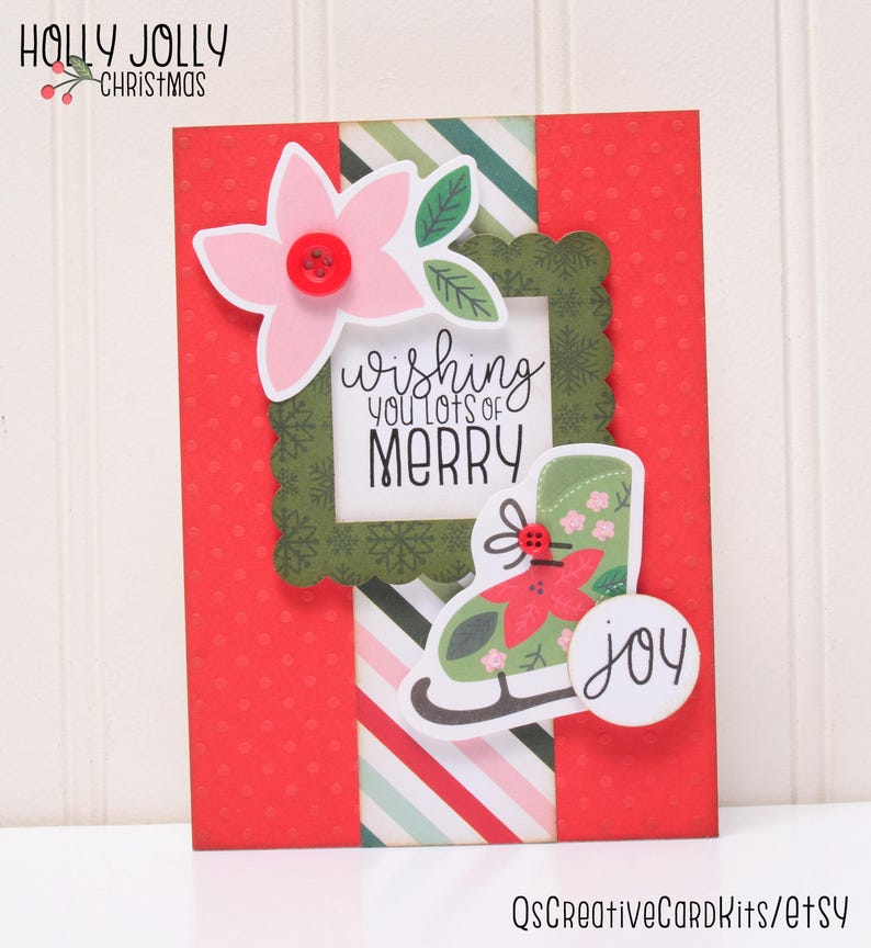 May include: A red and green Christmas card with a white frame that says "Wishing you lots of Merry". There is a green ice skate with a red flower on it and a white circle that says "joy".