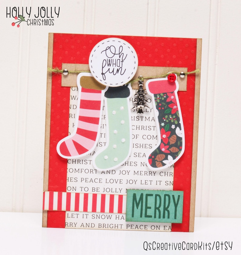 May include: A red and white striped paper with the words "HOLLY JOLLY CHRISTMAS" at the top.  The paper has a red background with white polka dots.  There are three Christmas stockings hanging from a string with a silver charm of a Christmas tree.  The stockings are red and white striped, green with white polka dots, and floral patterned.  The stockings are hanging from a circle with the words "Oh what fun" written in black.  The paper has the words "G HOLLY" and "CHRISTMAS" written in black.  The paper has the words "CHRIST COMFORT AND JOY MERRY CHR HES PEACE LOVE JOY LET IT SN ON TO BE JOLLY MERRY LET IT SNOW HA RRY AND BRIGHT PEACE ON EA" written in black.  There is a green and white striped paper with the word "MERRY" written in black.
