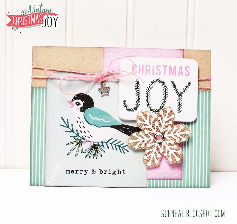 May include: A Christmas card with a vintage design featuring a blue bird on a branch, a snowflake, and the text "Christmas Joy" and "merry & bright".