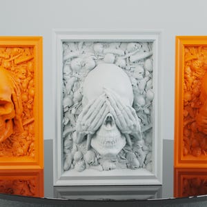 Peut inclure: Trois sculptures murales encadrées de crânes, chacune avec une expression différente. Le premier crâne se couvre les yeux avec ses mains, le deuxième crâne se couvre la bouche et le troisième crâne montre ses dents. Les sculptures sont toutes dans un schéma de couleurs blanc et orange.