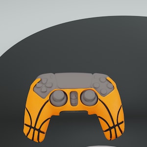May include: A grey and orange video game controller with a basketball pattern. The controller has two analogue sticks, a D-pad, and buttons.