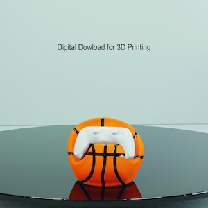 May include: A white video game controller resting inside an orange and black basketball. Digital Download for 3D Printing.