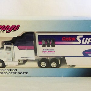 May include: A white diecast model truck with a blue and purple trailer. The trailer has the words "Castrol Super Clean" and a bottle of Super Clean cleaning product on it. The truck is part of the NHRA series.