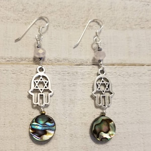 These Star of David Hamsa charm amulet earring  have Abalone shell discs, iridescent pink Austrian crystals and tiny bead drops.