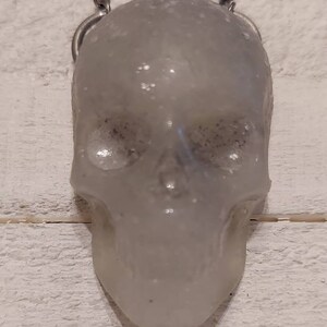 The FACETEDHEART Curated collection Glow in the Dark  glitter Resin Skull Talisman necklace.