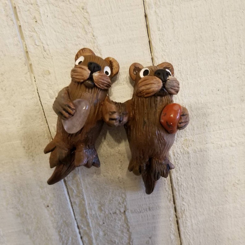 The Two Cute back floating Hand sculpted /painted Sea Otter Peg Dolls Holding Paws with Natural Tumbled Crystal Stones. image 1