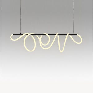 Puede incluir: Lámpara colgante moderna y minimalista. Una barra rectangular negra suspende un elemento de luz en bucle de color crema. La lámpara cuelga de dos finos cables sobre un fondo neutro.