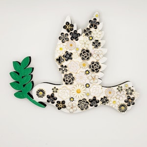 Dove of Peace Wall Décor, Peace Dove, Pentecost Dove, left-facing, made of painted wood, and adorned with pretty black and white charms.