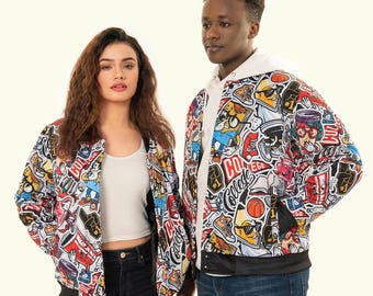 May include: Two people wearing white bomber jackets with a colorful, graphic print of cartoon characters, logos, and other designs. The jackets have black ribbed collars and cuffs.