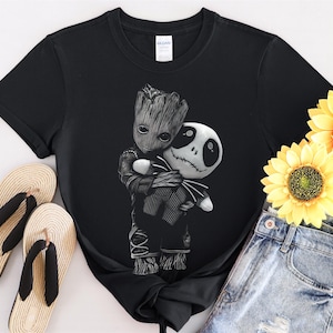 May include: Black t-shirt with a white graphic of a cartoon character, Groot, hugging another cartoon character, Jack Skellington.