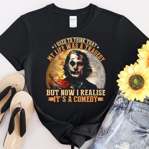 May include: Black t-shirt with a graphic of the Joker from the movie "Joker" with the text "I used to think that my life was a tragedy but now I realize it's a comedy."