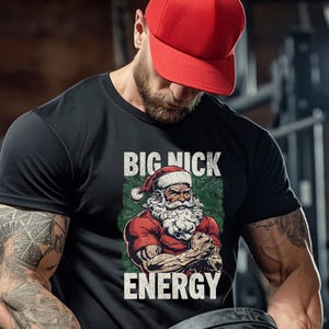 May include: A black t-shirt with a graphic of a muscular Santa Claus with the text "BIG NICK ENERGY" printed on it.