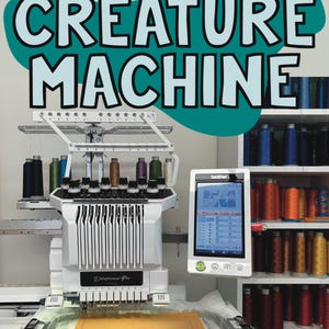 May include: A white and silver Entrepreneur Pro embroidery machine with a Brother control panel. The image features the text "CREATURE MACHINE" and shelves of colorful thread spools. The machine is set up with a tan fabric piece.