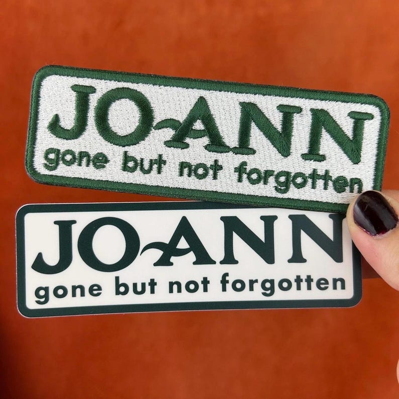 May include: Two rectangular patches with the name "JO-ANN" and the phrase "gone but not forgotten". One patch is embroidered with green text on a white background, the other is a sticker with the same design.