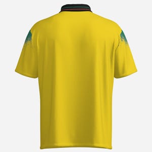 Puede incluir: Un polo amarillo con cuello negro con rayas verdes y rojas. Los hombros tienen un dise&ntilde;o de salpicaduras de pintura azul y verde. La camisa tiene mangas cortas y un dise&ntilde;o de polo cl&aacute;sico.