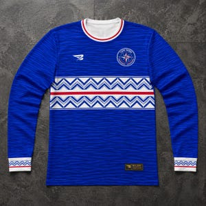 May include: A long-sleeved blue jersey with white and red accents. The jersey features a zig-zag pattern across the chest and the words "CAPE VERDE" on the upper right chest. The jersey has a white collar and cuffs.