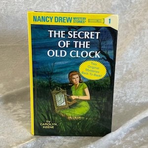 May include: A vintage copy of "The Secret of the Old Clock," a Nancy Drew Mystery Stories book. The cover shows a woman in a green dress with a clock, set against a dark blue backdrop with yellow borders. Written by Carolyn Keene.