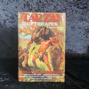 Może przedstawiać: Książka w stylu vintage zatytułowana "Tarzan of the Apes" autorstwa Edgara Rice'a Burroughsa. Okładka przedstawia ilustrację Tarzana walczącego z małpą. Książka jest kompilacją czterech tomów, z tytułami wymienionymi pod nazwiskiem autora. Książka jest w całości i zilustrowana.