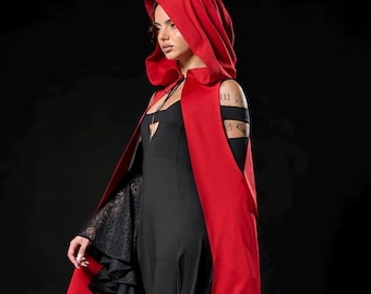 May include: A long, flowing black dress with a matching red hooded cape. The cape has a deep red exterior and a black interior. The sleeves of the dress are black lace. The outfit is set against a black background.