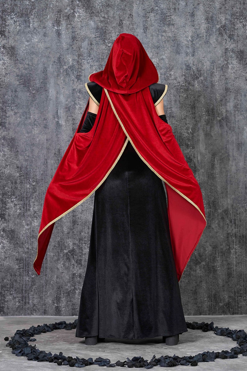May include: A black velvet gown with a red velvet hooded cape, trimmed with gold. The cape is draped over the shoulders and arms. The costume is suitable for Halloween or cosplay events.