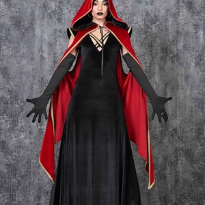 May include: A black velvet dress with a plunging neckline and a red hooded cape with gold trim. The long black gloves and dramatic makeup complete the gothic ensemble, perfect for a costume or themed event.