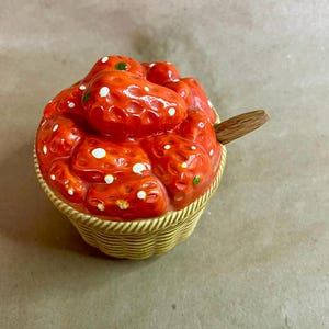 May include: A white ceramic mug with a black handle and the text "But First, Coffee" in a handwritten style. The mug is on a white surface. The mug is 4 inches tall.