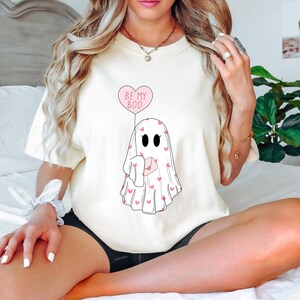 May include: White t-shirt with a ghost holding a pink heart balloon that says "Be My Boo".