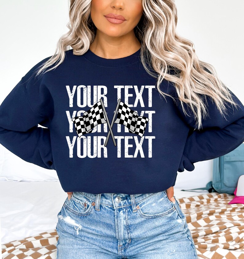 May include: Navy blue sweatshirt with a white graphic of two checkered flags crossed over each other. The text "YOUR TEXT" is repeated three times in a distressed white font.