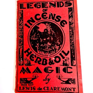 May include: A red book cover with black text and illustrations. The title reads Legends of Incense, Herb & Oil Magic by Lewis de Claremont. The cover features a central circular graphic of a cauldron, decorative borders, and oil lamps.
