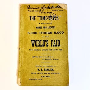 May include: A vintage, yellowed booklet titled "THE 'TIME-SAVER'" with black text. The cover advertises a guide to 5,000 things at the World's Fair. The booklet is compiled and published by W. E. Hamilton.