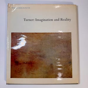 May include: A book cover titled "Turner: Imagination and Reality" from The Museum of Modern Art, New York. The cover features a painting with shades of brown, red, and orange. The book has a white border and a glossy finish.