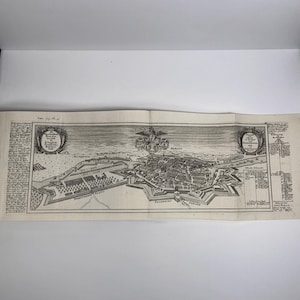 May include: An antique black and white map of Berlin, Germany, with detailed illustrations of the city's layout, including buildings, streets, and fortifications. The map features decorative elements and text in German.