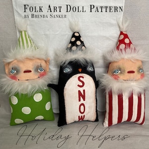 May include: Three handmade felt holiday dolls. A green and white elf doll with white polka dots, a black and white penguin doll with the word "SNOW" on its belly, and a red and white Santa doll with red and white stripes.