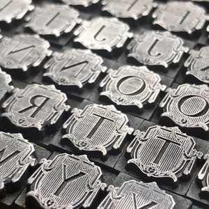 Elija sus letras - Bloques de impresión de cartas de tipo antiguo - Serif Font en el escenario Art Deco con presentación de cortina