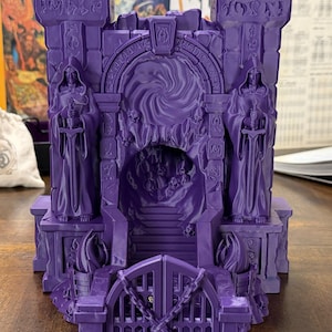 May include: A detailed purple miniature castle gate with two robed figures holding swords. The gate features a spiral design and skull accents. The miniature is designed for tabletop gaming.