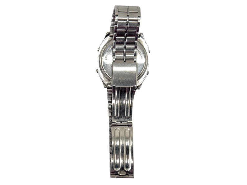Puede incluir: Un reloj de pulsera plateado con una correa de metal. La esfera del reloj es visible y la correa est&aacute; parcialmente abierta. El reloj parece estar hecho de acero inoxidable. El reloj se muestra sobre un fondo blanco.