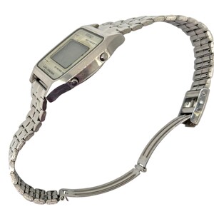 Puede incluir: Un reloj de pulsera digital plateado con una pantalla rectangular y una correa de metal a juego. El reloj est&aacute; en &aacute;ngulo, mostrando la esfera y la correa flexible, que est&aacute; parcialmente desabrochada.