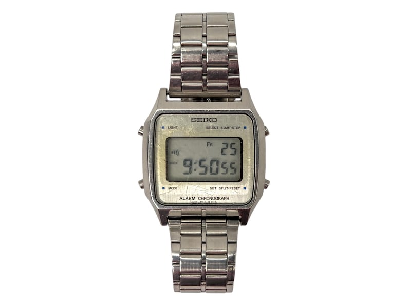 Puede incluir: Un reloj digital Seiko plateado con una esfera rectangular y una correa de metal a juego. El reloj muestra la hora como 9:50:55, con el d&iacute;a y la fecha como Vi 25. El reloj tiene botones para luz, modo y cron&oacute;grafo de alarma.