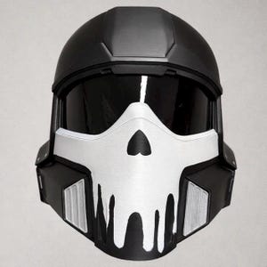 Op de afbeelding: Een zwart-witte helm met een schedelontwerp op het gezicht. De helm heeft een vizier en is waarschijnlijk bedoeld voor cosplay of kostuumgebruik. Het schedelontwerp is wit met zwarte accenten.