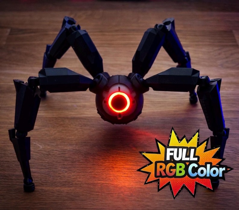 May include: A black, mechanical spider-like robot with articulated legs and a central body featuring a glowing red ring. The image includes the text "FULL RGB Color" in a starburst graphic.