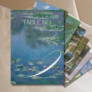 Peut inclure: Un ensemble de cartes de numéro de table avec un motif de nénuphars bleu et vert. Les cartes comportent le texte "TABLE NO." et un numéro blanc. Les cartes sont parfaites pour un mariage ou un autre événement spécial.
