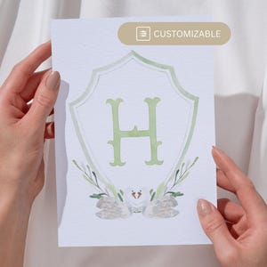 May include: A white card with a green watercolor crest featuring the letter "H" and two white doves. The crest is surrounded by green watercolor leaves. The card has the word "CUSTOMIZABLE" printed in a small box in the top right corner.