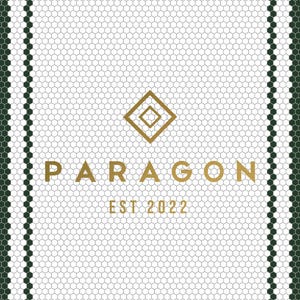 以下が含まれることがあります： 白いハニカム模様と濃い緑色のボーダーの幾何学模様。 「PARAGON」の文字が金色の文字で表示され、その下に「EST 2022」と表示されています。 上部には金色のひし形ロゴがあります。