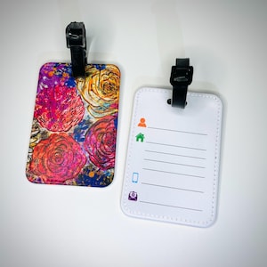 Bagagelabel met riem om aan de koffers en handbagage te bevestigen. Bloeiende collectie van Dahlo Roses. Voorzien van artwork van DAHLO.