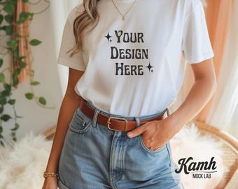 Könnte beinhalten: Weißes T-Shirt mit dem Text "YOUR DESIGN HERE" in schwarzer, Vintage-Schrift. Das Model trägt Jeansshorts und einen braunen Gürtel. Das Shirt ist eine leere Leinwand für individuelle Designs.