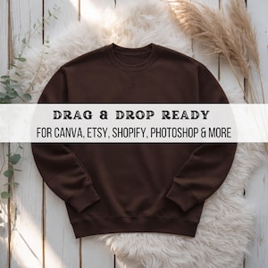 Peut inclure: Un sweat-shirt marron fonc&eacute; &agrave; col rond, pr&eacute;sent&eacute; sur une surface blanche et duveteuse. Le texte "DRAG & DROP READY FOR CANVA, ETSY, SHOPIFY, PHOTOSHOP & MORE" est affich&eacute; sur le v&ecirc;tement.
