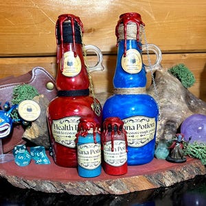 May include: Red and blue potion bottles with decorative labels and dripped wax tops. The bottles have handles and are adorned with chains. Smaller bottles of potions are also present, along with dice and a miniature figurine.