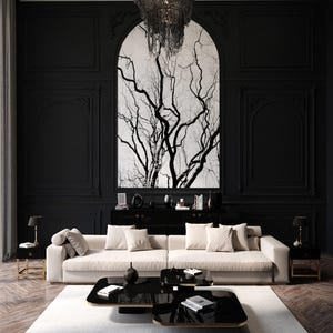 Puede incluir: Un sofá blanco con detalles negros se encuentra en una sala de estar moderna con una mesa de café negra y una impresión de árbol en blanco y negro en la pared.