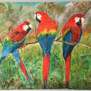 Op de afbeelding: Een acrylverfschilderij van drie ara's die op een tak zitten. De vogels hebben rode, blauwe, gele en groene veren. De achtergrond is een gestructureerde, impressionistische bosscène met groene en bruine tinten.